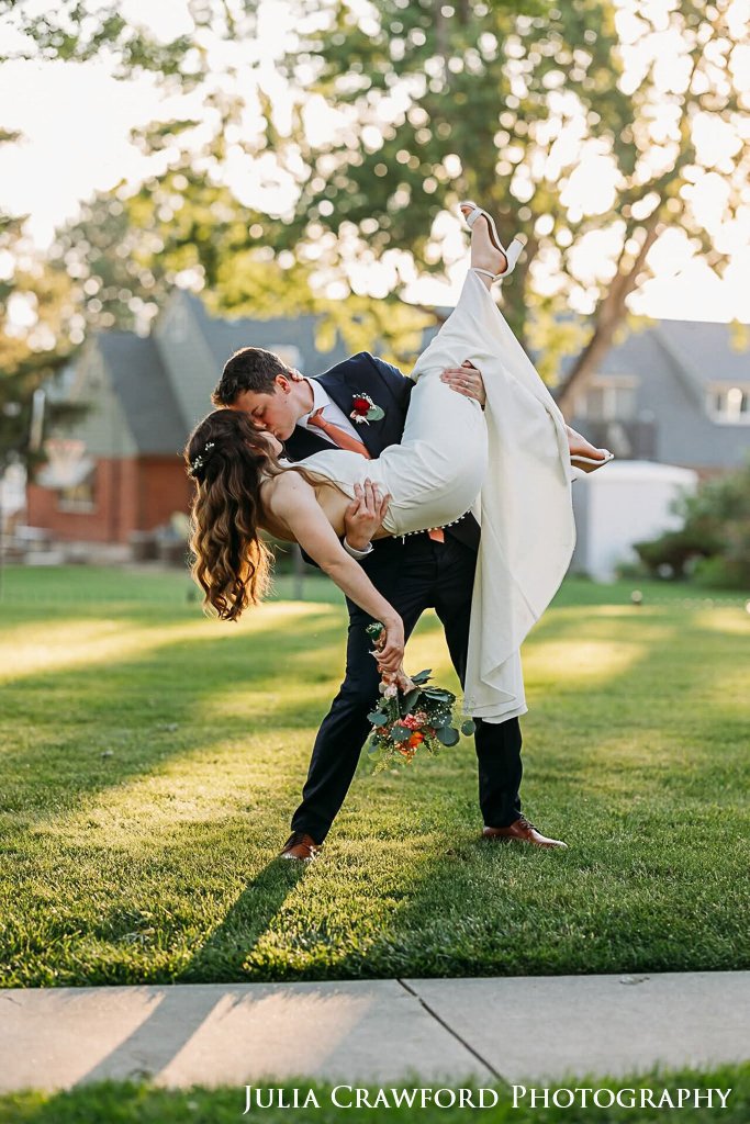Groom dipping his bride for a kiss on the lawn